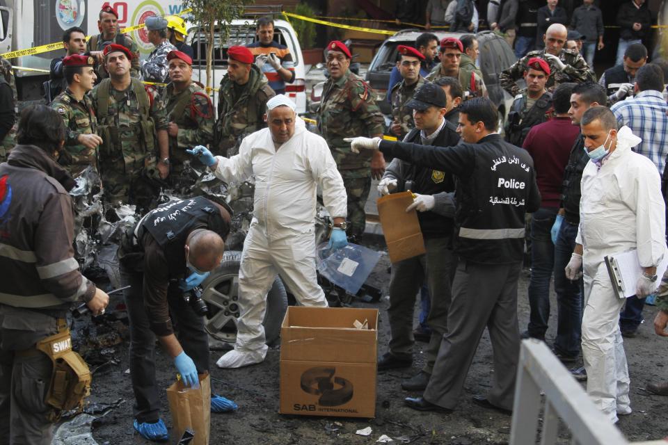 Lebanese army soldiers gather around as forensic inspectors examine the site following an explosion in the Haret Hreik area in the southern suburbs of the Lebanese capital Beirut