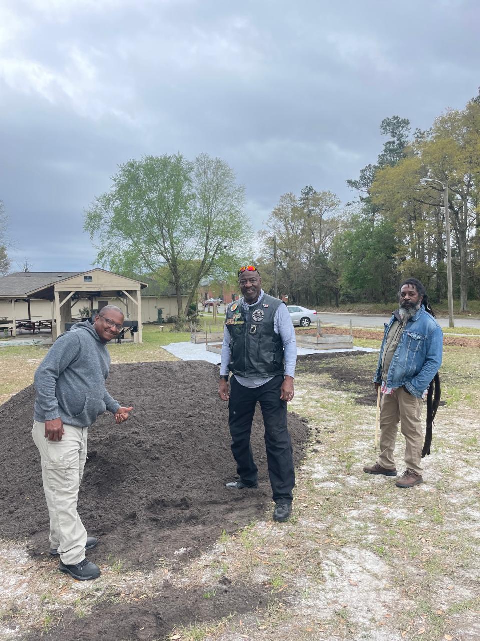 Picture from left, Nate Mitchell of Feast Down East, Pastor James Jamison of Hope For All Nations Baptist Church, and Melvin Melbourne of Sokoto House stand in front of the future Hope Community Garden.