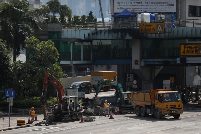 Workers repair toll booths damaged during protests, outside the Hong Kong Polytechnic University (PolyU) in Hong Kong