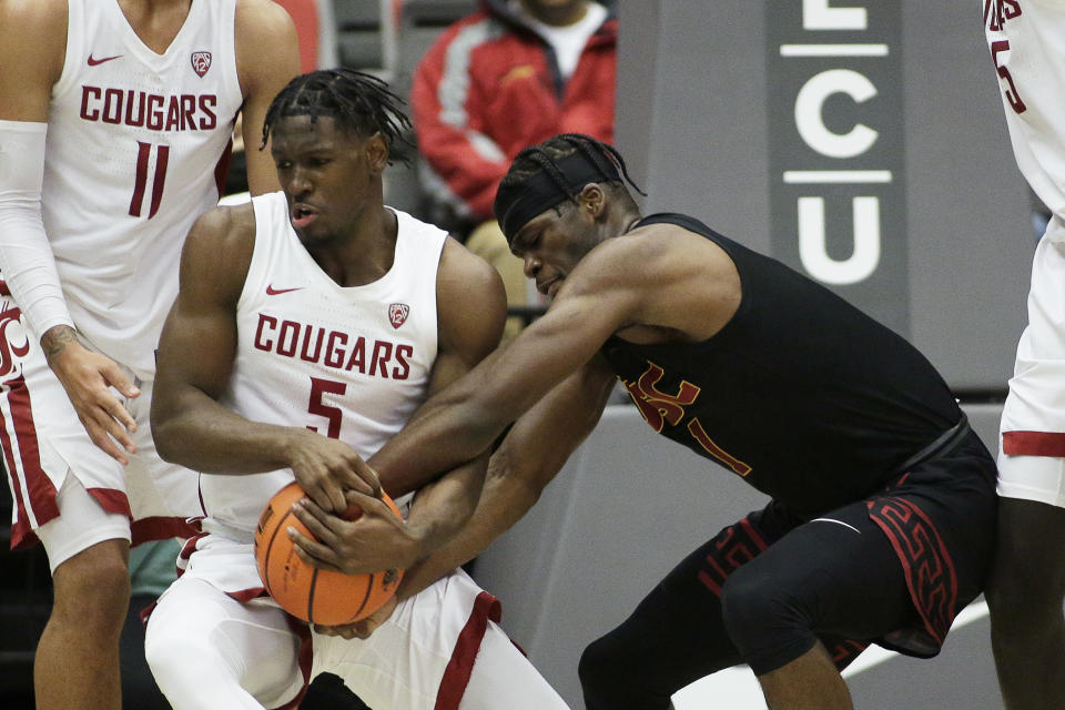 Washington State guard TJ Bamba, left, and Southern California forward Chevez Goodwin vie for the ball during the first half of an NCAA college basketball game, Saturday, Dec. 4, 2021, in Pullman, Wash. (AP Photo/Young Kwak)