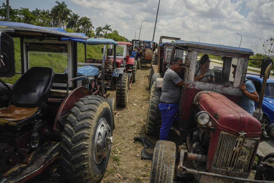 Farm workers wait in line to refuel their tractors on the highway to Pinar del Rio, Guanajay, Cuba, Thursday, May 18, 2023. Cuba is in the midst of an acute fuel shortage that has drivers and farmers waiting in line for days or even weeks in order to fuel up their vehicles and tractors. (AP Photo/Ramon Espinosa)