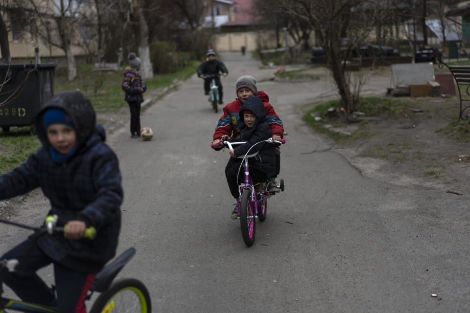 Children play in Bucha, on the outskirts of Kyiv, Ukraine, Wednesday, April 13, 2022. (AP Photo/Rodrigo Abd)