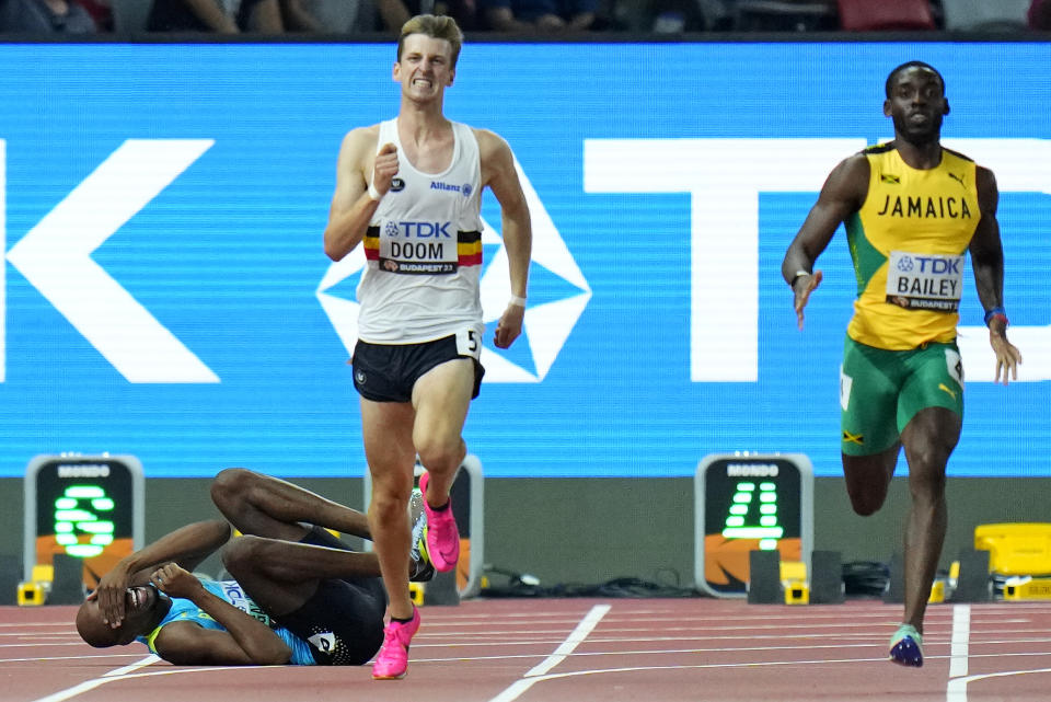 Steven Gardiner, of Bahamas, left, reacts as he pulls up injured in a Men's 400-meters semifinal during the World Athletics Championships in Budapest, Hungary, Tuesday, Aug. 22, 2023. (AP Photo/Petr David Josek)