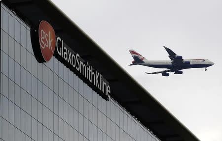 A British Airways airplane flies past a signage for pharmaceutical giant GlaxoSmithKline (GSK) in London April 22, 2014. REUTERS/Luke MacGregor