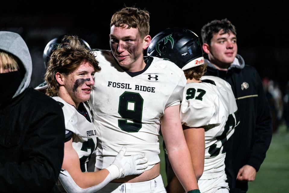 Fossil Ridge's Jake Toshcoff (22) and Theo Frericks (9) embrace after a Class 5A football playoff game vs. Regis Jesuit in Aurora, Colo. on Friday, Nov. 11, 2022.