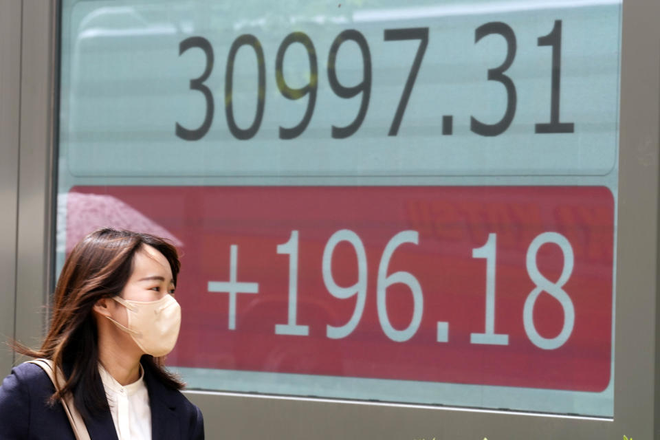 A person walks in front of an electronic stock board showing Japan's Nikkei 225 index at a securities firm Friday, May 26, 2023, in Tokyo. Asian markets were mixed Friday as a deadline loomed for Congress to reach a deal on the U.S. government debt or face a potentially calamitous default. (AP Photo/Eugene Hoshiko)