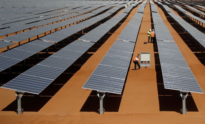 Workers set up the photovoltaic solar panels at the Benban plant in Aswan