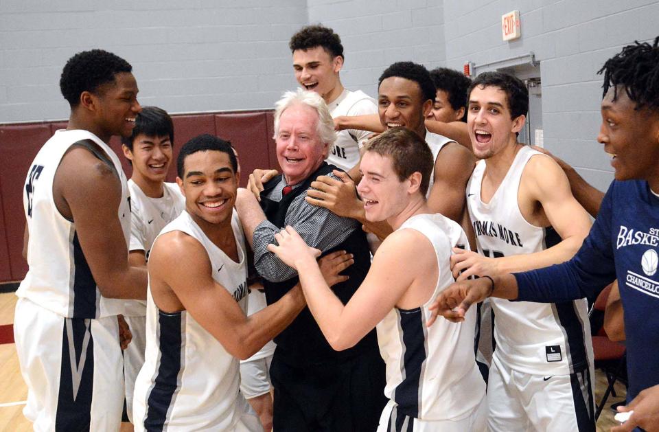 Jere Quinn, Saint Thomas More's basketball coach, is congratulated by his team on his 1,000th victory in a game with Worcester Academy Jan. 24, 2018, in Worcester, Massachusetts.