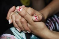 <p>Bringing the personalized elements of a varsity jacket to the nails, Rita Remark for Essie used polishes Blanc and Really Red to give it the “M” stamp of approval. (Photo: Essie) </p>