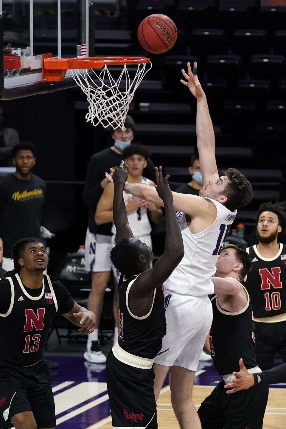 Northwestern center Ryan Young, center, shoots against Nebraska forward Lat Mayen and guard Thorir Thorbjarnarson during the second half of an NCAA college basketball game in Evanston, Ill., Sunday, March 7, 2021. (AP Photo/Nam Y. Huh)