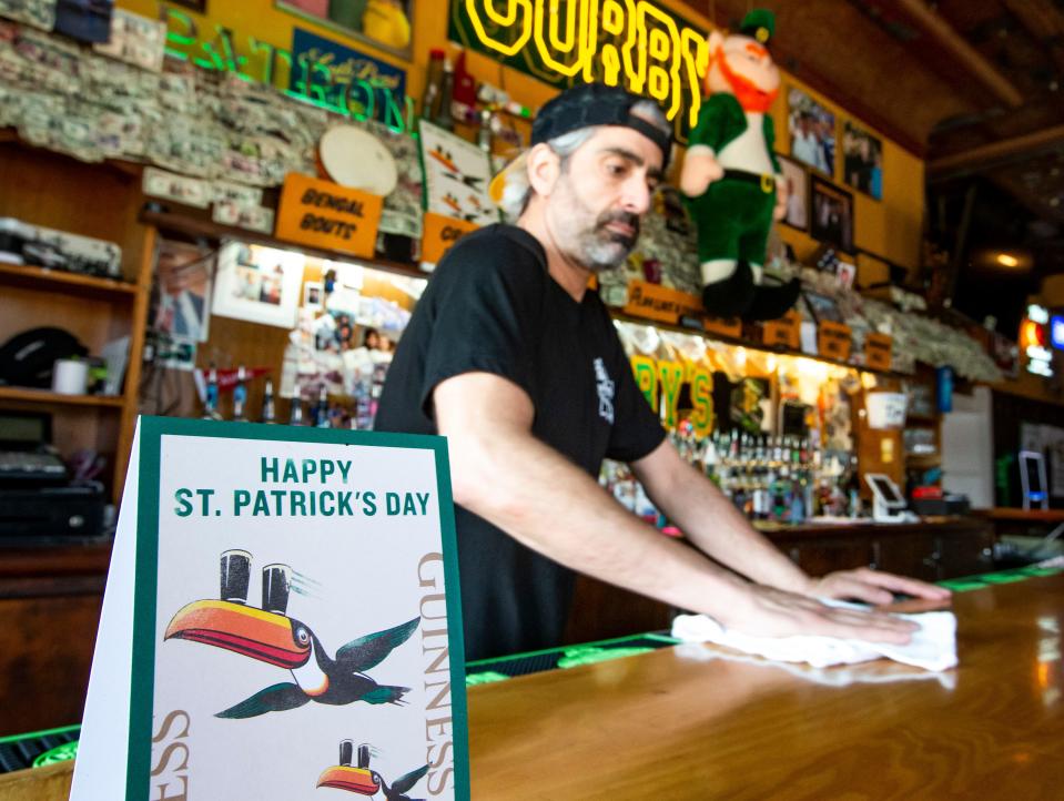 Joe Mittiga wipes down the bar as St. Patrick’s Day decorations are in place inside Corby’s on Wednesday, March 9, 2022, in South Bend. 