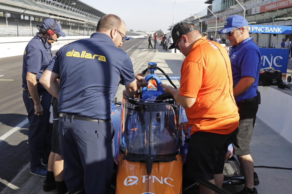 Crew members and engineers look at the Aeroscreen on the car of Scott Dixon, of New Zealand, during testing at Indianapolis Motor Speedway, Wednesday, Oct. 2, 2019, in Indianapolis. (AP Photo/Darron Cummings)