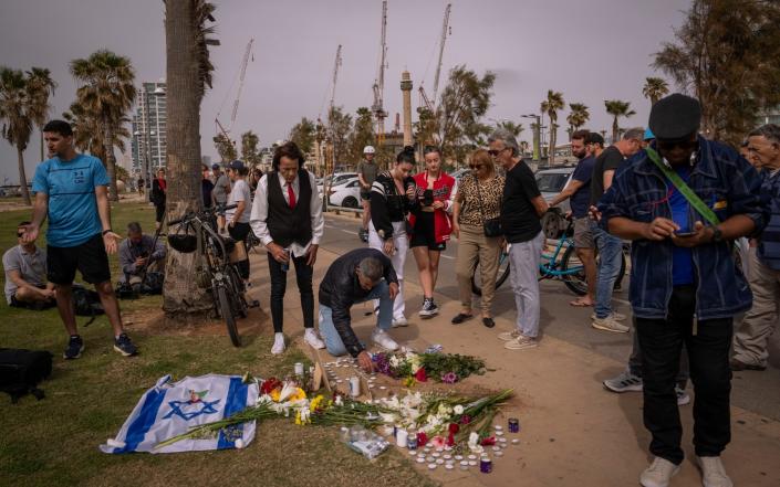 People leave floral tributes for the Italian victim of the Tel Aviv attack - Oded Balilty/AP