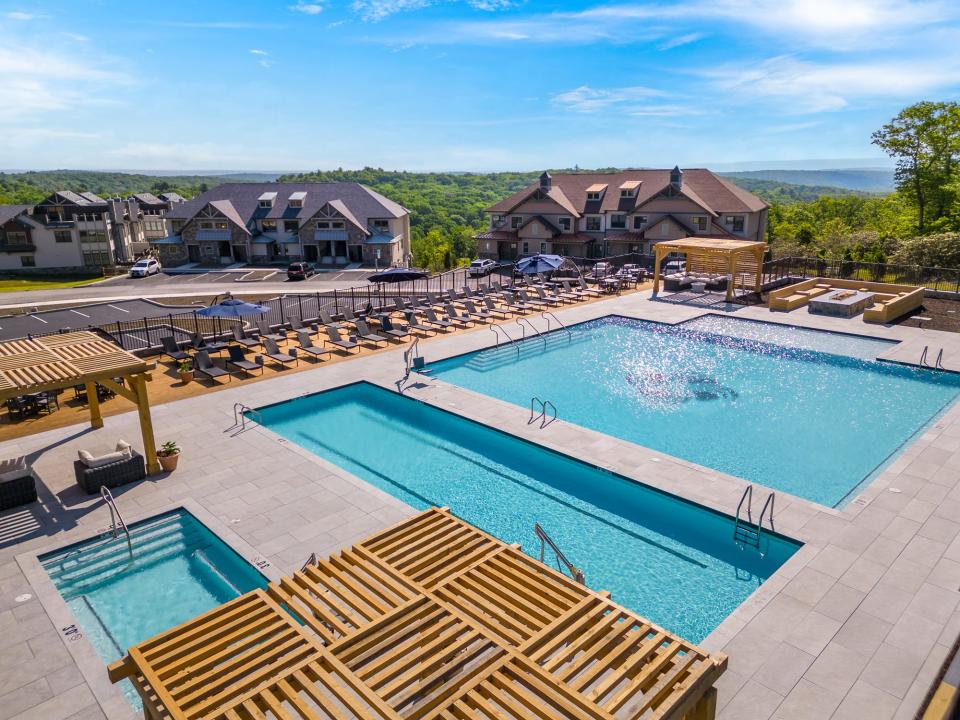 As shown in this rendering, the Serenité pool is a 4,000-square-foot-plus luxury outdoor pool with detached lap lanes (heated all four seasons), oversized hot tub, granite fire table, and swim deck social area.