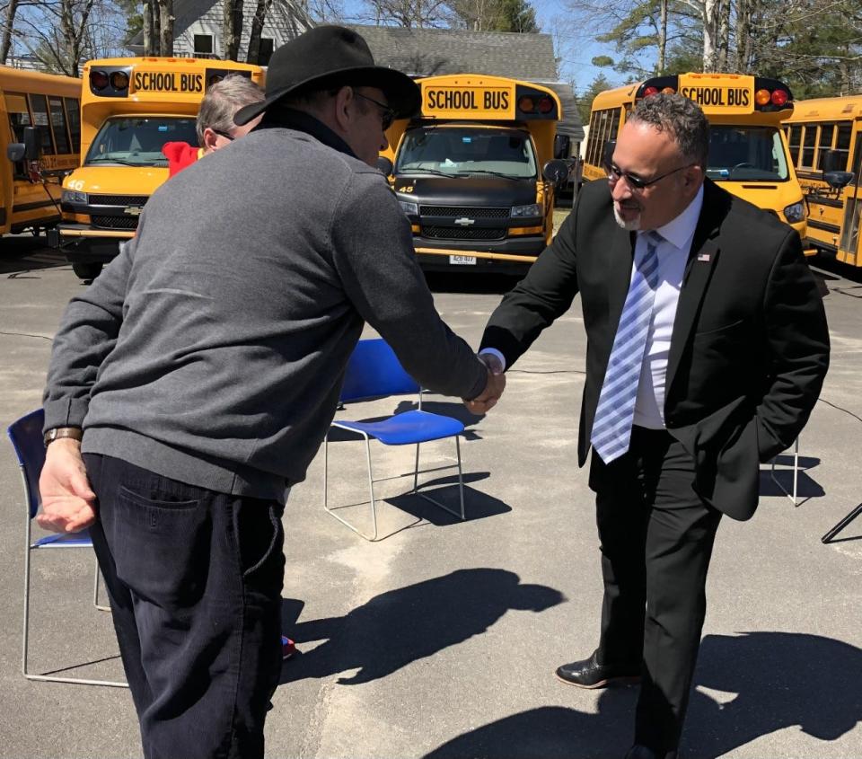 Dennis Duprey, left, the vice president of the local Transportation Employees Association, meets U.S. Education Secretary Dr. Miguel Cardona in Kennebunk on Monday, April 11, 2022.