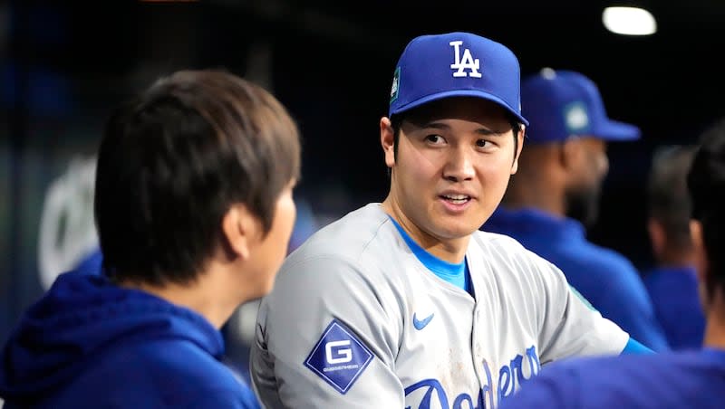 Los Angeles Dodgers designated hitter Shohei Ohtani, right, talks with interpreter Ippei Mizuhara during the ninth inning of an opening day baseball game against the San Diego Padres at the Gocheok Sky Dome in Seoul, South Korea, Wednesday, March 20, 2024.