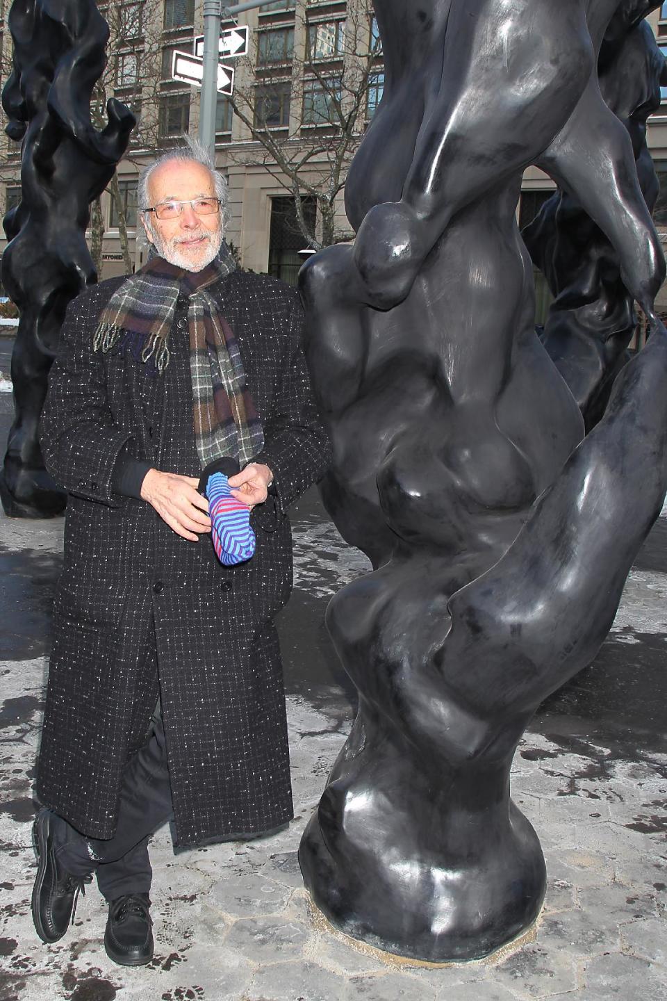 This image released by Starpix shows musician-artist Herb Alpert standing next to one of three black bronze totem sculptures on display at Dante Park on West 64th Street and Broadway, Thursday, Jan 23, 2014 in New York. The sculptures will be on display until April 15. (AP Photo/Starpix, Dave Allocca)