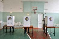 Voters read their ballots at a polling station in a school's sport hall during a parliamentary elections in Yerevan, Armenia, Sunday, June 20, 2021. Armenians are voting in a national election after months of tensions over last year's defeat in fighting against Azerbaijan over the separatist region of Nagorno-Karabakh. (Karo Sahakyan/PAN Photo via AP)