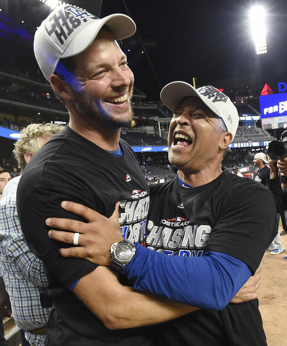 Los Angeles Dodgers Rich Hill, left, and Los Angeles Dodgers manager Dave Roberts embrace after Game 4 of baseball's National League Division Series Atlanta Braves, Monday, Oct. 8, 2018, in Atlanta. The Los Angeles Dodgers won 6-2. (AP Photo/John Amis)