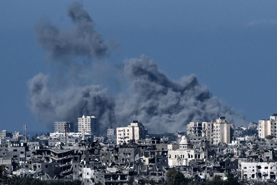 A picture taken from the Israeli side of the border with the Gaza Strip shows smoke rising behind destroyed buildings in the norther-western part of the Palestinian enclave during an Israeli bombing on Oct. 21, 2023, amid the ongoing battles between Israel and Hamas.