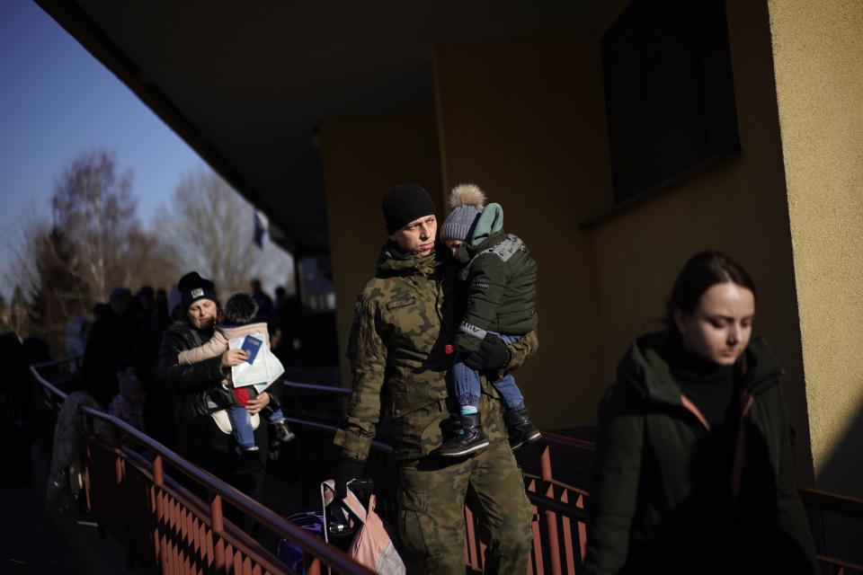 A Polish soldier holds a child as Ukrainian refugees arrive from Lviv to Przemysl train station, southeastern Poland, on Friday, March 11, 2022. Thousands of people have been killed and more than 2.3 million have fled the country since Russian troops crossed into Ukraine on Feb. 24. (AP Photo/Daniel Cole)