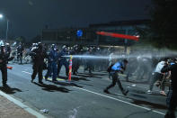 Washington Metropolitan Police Department police officers shoot pepper spray at demonstrators outside of the fourth district police station in Washington, Wednesday, Oct. 28, 2020. Demonstrators gathered at the police station in protest over a fatal a crash involving a moped driver who died when he police were attempting to pull him over. The crash happened last Friday. (AP Photo/Jose Luis Magana)