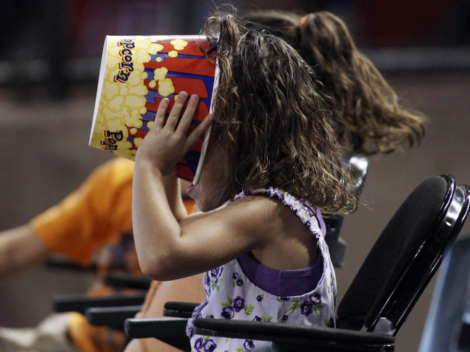 El ansia ha podido con esta pequeña forofa estadounidense. Estaba viendo un partido de baseball en Phoenix y se le acabaron las palomitas. Pero por si acaso quedaba alguna migaja metió la cabeza en busca de lo que pudiera quedar dentro. Si encontró algo o no, solo ella lo sabe. (REUTERS/Darryl Webb)