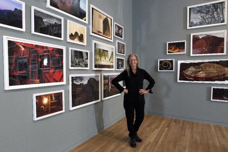 Annie Leibovitz stands near some of her work before the opening of her exhibition at the Wexner Center for the Arts Friday, Sept. 21, 2012, in Columbus, Ohio. Leibovitz's exhibition features work from her “Master Set,” an authoritative edition of 156 images. (AP Photo/Jay LaPrete)