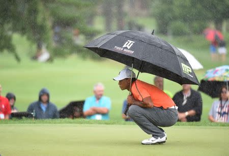 Tiger Woods studies the 10th green while holding an umbrella at The Old White TPC. Mandatory Credit: Bob Donnan-USA TODAY Sports