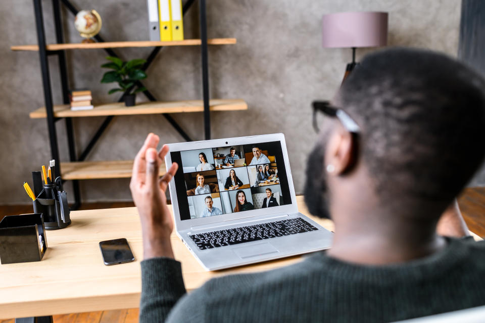 A man attends a virtual meeting in a hybrid office. 