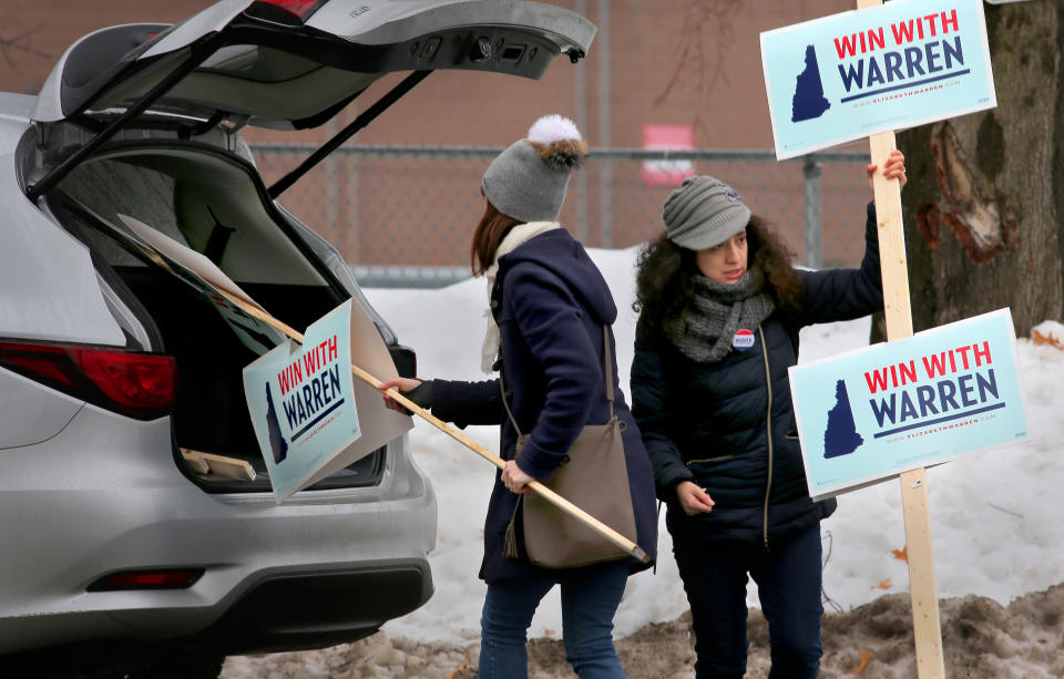 MANCHESTER, NH - FEBRUARY 11: Elizabeth Warren volunteers Meredith Osborn and Krystal Lay deliver signs to other volunteers outside a polling place on election day in Manchester, NH on Feb. 11, 2020.  The first-in-the-nation New Hampshire primary is today. (Photo by Lane Turner/The Boston Globe via Getty Images)