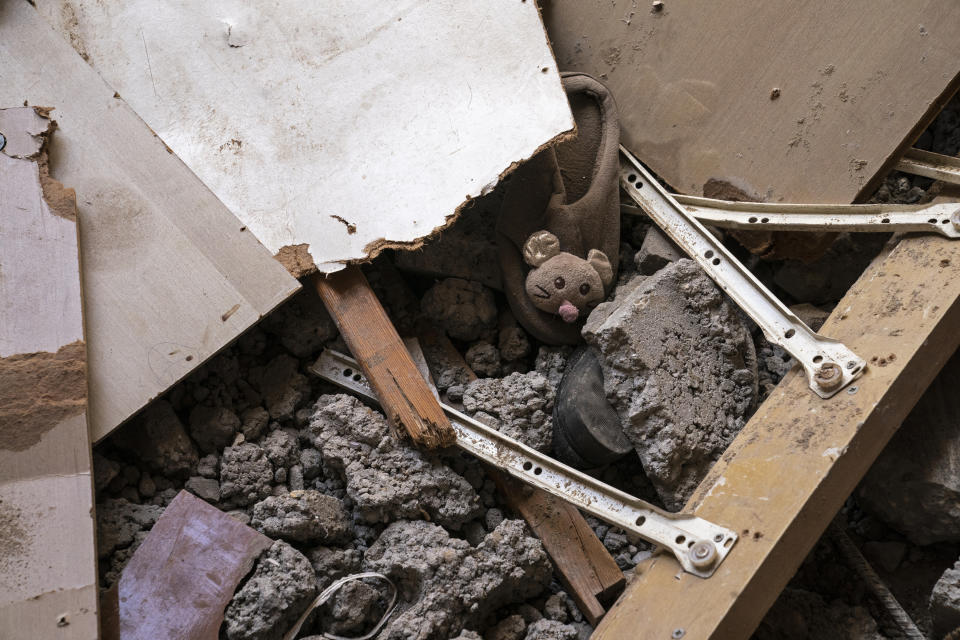 A child's slipper is partially buried under rubble of a severely damaged building beside the crater where the home of Ramez al-Masri was destroyed by an air-strike prior to a cease-fire reached after an 11-day war between Gaza's Hamas rulers and Israel, Sunday, May 23, 2021, in Beit Hanoun, the northern Gaza Strip. (AP Photo/John Minchillo)