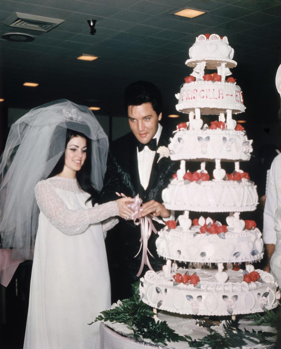 priscilla presley and elvis presley cutting their wedding cake