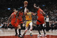 Los Angeles Lakers' Russell Westbrook drives between Toronto Raptors' Gary Trent Jr., left, and Christian Koloko during the first half of an NBA basketball game Wednesday, Dec. 7, 2022, in Toronto. (Chris Young/The Canadian Press via AP)