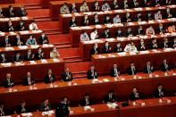 Chinese President Xi Jinping and other officials applaud after the vote on the national security legislation for Hong Kong Special Administrative Region at the closing session of NPC in Beijing