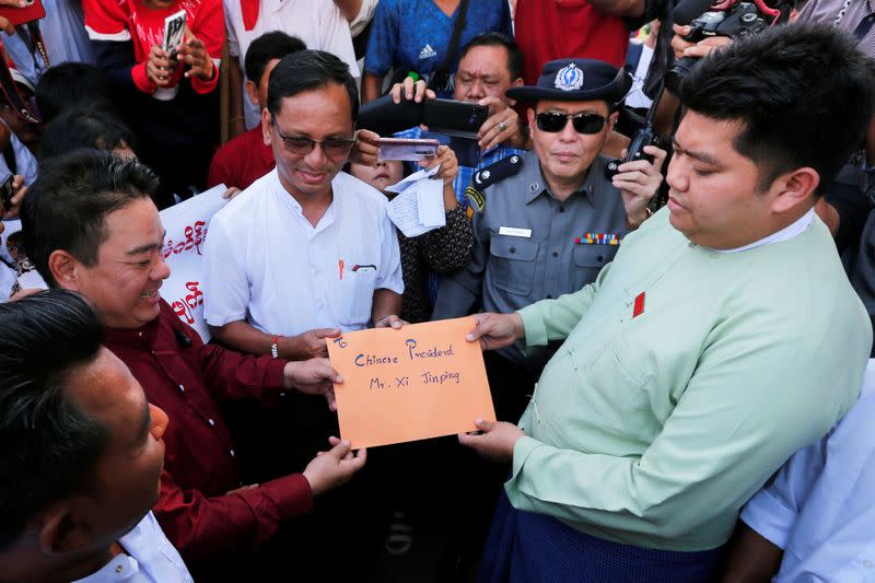 Protesters hold a letter addressed to Chinese President Xi Jinping against Myitsone hydropower dam during the last day of his visit in Yangon