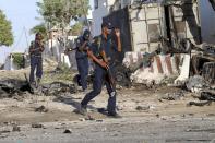 Security guards assess the aftermath at the scene of an explosion outside Jazira hotel in Mogadishu, January 2, 2014. Three bombs exploded within an hour outside the hotel in a heavily fortified district of the Somali capital on Wednesday, killing at least 11 people. (REUTERS/Omar Faruk)