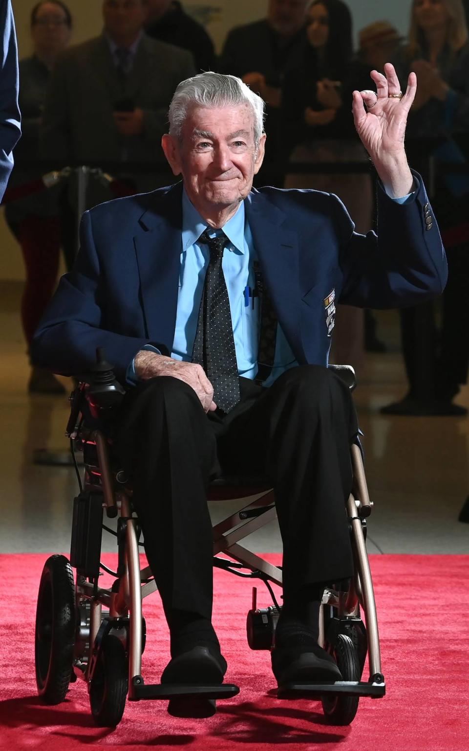 NASCAR Hall of Fame member Bobby Allison acknowledges the cheers of the fans along the red carpet at the NASCAR Hall of Fame in Charlotte, NC on Friday, January 19, 2024.