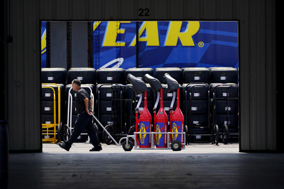 A crew member pulls a cart of fuel through the garage area before practice for Saturday's NASCAR Truck Series auto race at Pocono Raceway, Friday, July 22, 2022, in Long Pond, Pa. (AP Photo/Matt Slocum)