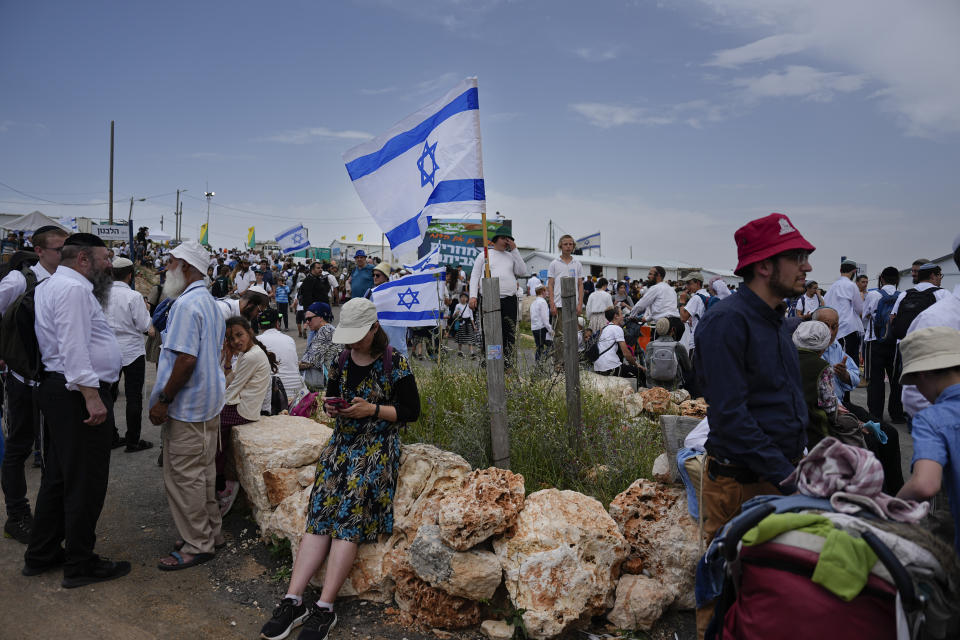 Israeli settlers walk around the outpost of Eviatar in the West Bank, Monday, April 10, 2023. Thousands led by hardline ultranationalist Jewish settlers marched to the unauthorized settlement outpost Eviatar in the northern West Bank that was cleared by the Israeli government in 2021, protected by a large contingent of Israeli soldiers and police. (AP Photo/Ariel Schalit)