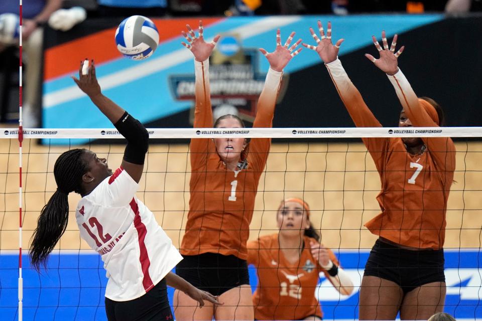 Wisconsin's Temi Thomas-Ailara sends a spike toward Texas players Ella Swindle and Asjia O'Neal during the Longhorns' national semifinal victory Thursday. Texas knocked out three No. 1 seeds en route to winning its second straight NCAA championship.