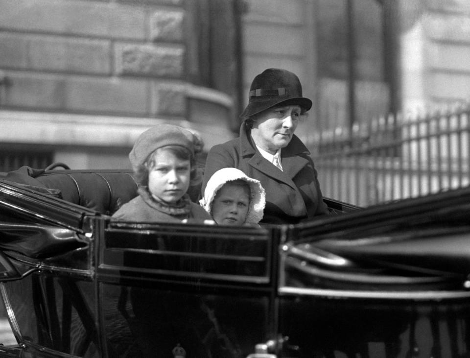 Princess Elizabeth (left, later Queen Elizabeth II) and her sister Princess Margaret Rose out for a ride with their nanny in their horse-drawn carriage, in 1933. (PA )