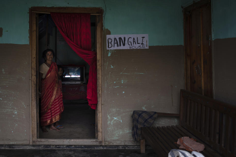 A woman stands by the door of her home marked with her ethnicity in fears that they could be attacked due to mistaken identity in village Siden, near Churachandpur, in the northeastern Indian state of Manipur, Tuesday, June 20, 2023. Manipur is caught in a deadly conflict between two ethnic communities that have armed themselves and launched brutal attacks against one another. At least 120 people have been killed since May. (AP Photo/Altaf Qadri)