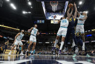 Indiana Pacers center Goga Bitadze (88) shoots between Charlotte Hornets defenders P.J. Washington (25) and Kelly Oubre Jr. during the first half of an NBA basketball game in Indianapolis, Wednesday, Jan. 26, 2022. (AP Photo/AJ Mast)