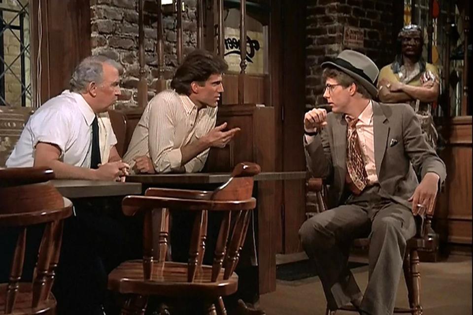 Three men sitting around a table at a bar.