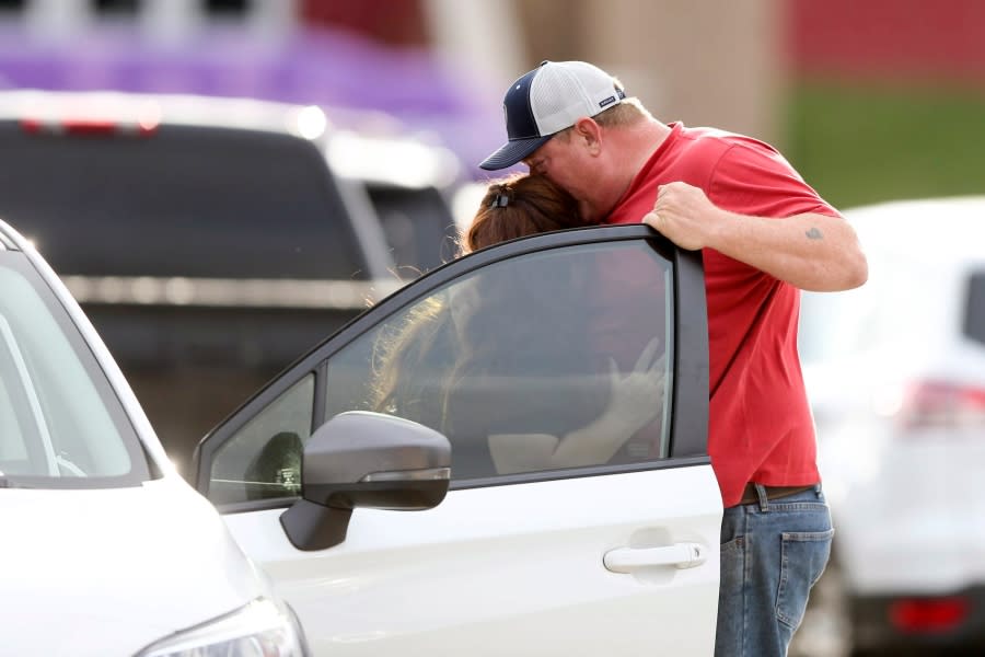 Family members hug as they are reunited at Memorial High School after being evacuated from the scene of a shooting at the Natalie Medical Building Wednesday, June 1, 2022. in Tulsa, Okla. Multiple people were shot at a Tulsa medical building on a hospital campus Wednesday. (Ian Maule/Tulsa World via AP)