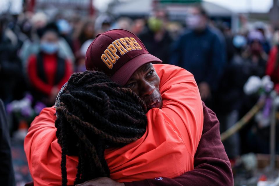 People hug on the street.