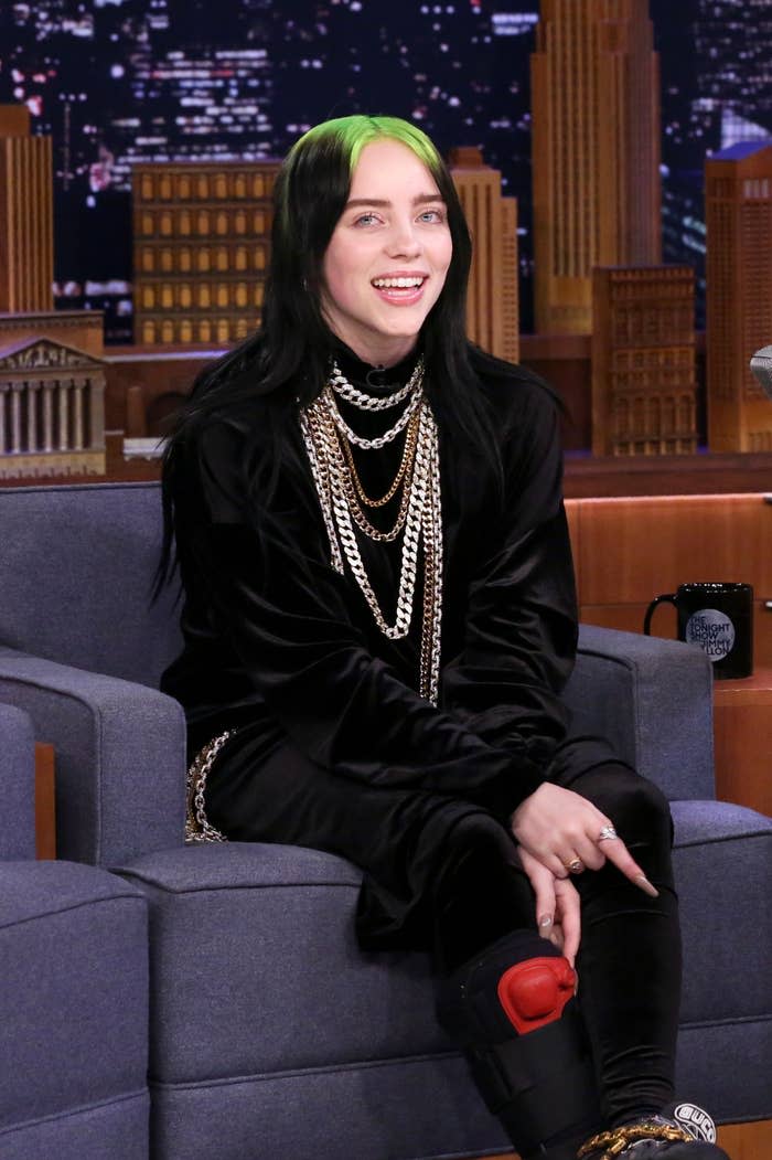 Billie Eilish smiles as she sits onstage on the The Tonight Show with Jimmy Fallon