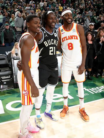 Gary Dineen/NBAE/Getty Aaron Holiday #3 of the Atlanta Hawks, Jrue Holiday #21 of the Milwaukee Bucks and Justin Holiday #8 of the Atlanta Hawks take a photo together during a game.