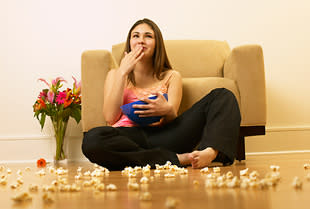 woman eating popcorn on the floor